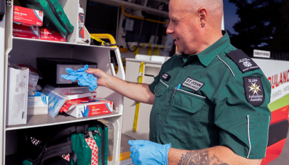 Man restocking first aid equipment from an ambulance
