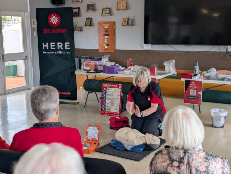 St John trainer demonstrating CPR techniques to older members of the community.