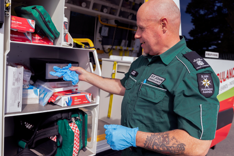 Man restocking first aid equipment from an ambulance