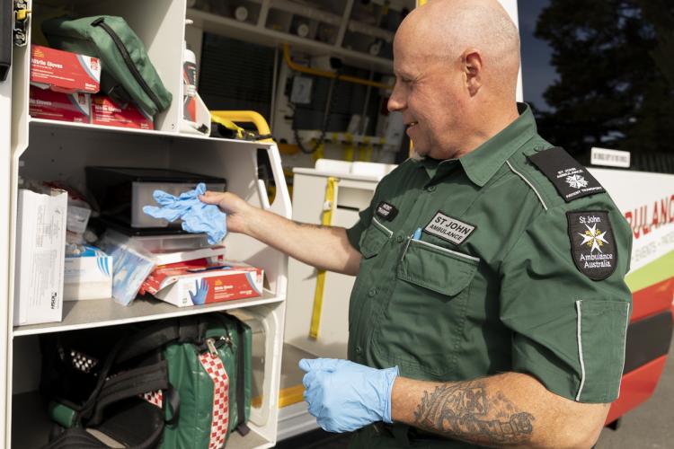 Man restocking first aid equipment from an ambulance